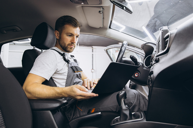 Worker inside his car operating a computer